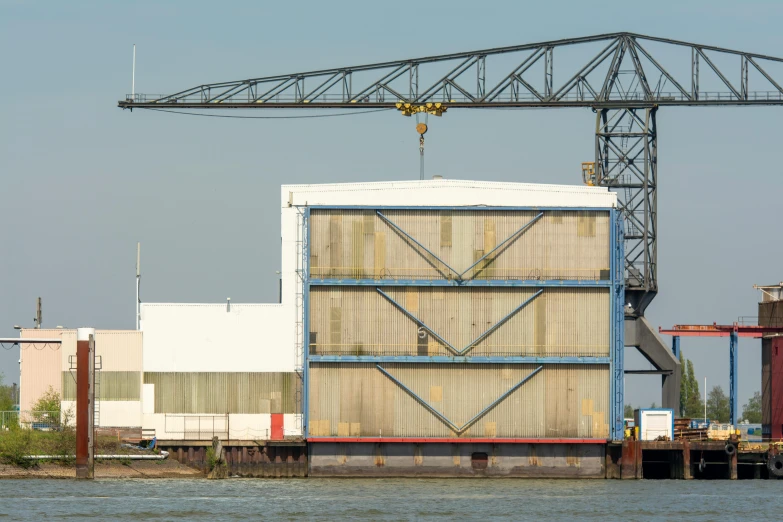 an old crane hanging from a wooden structure over water