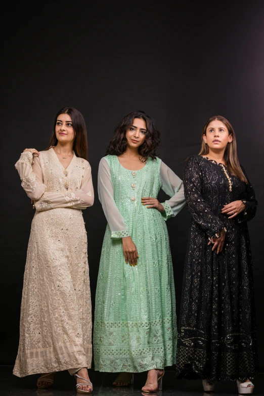 three women standing in front of a black background