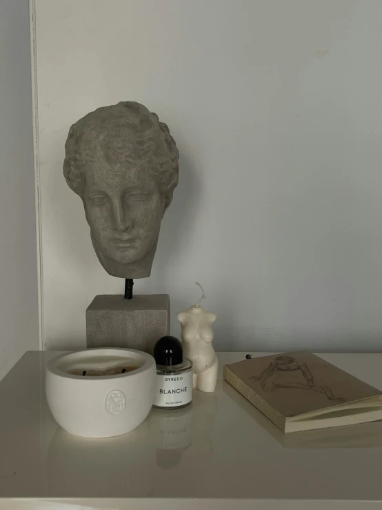 the grey room with a book, cup, and head is pictured