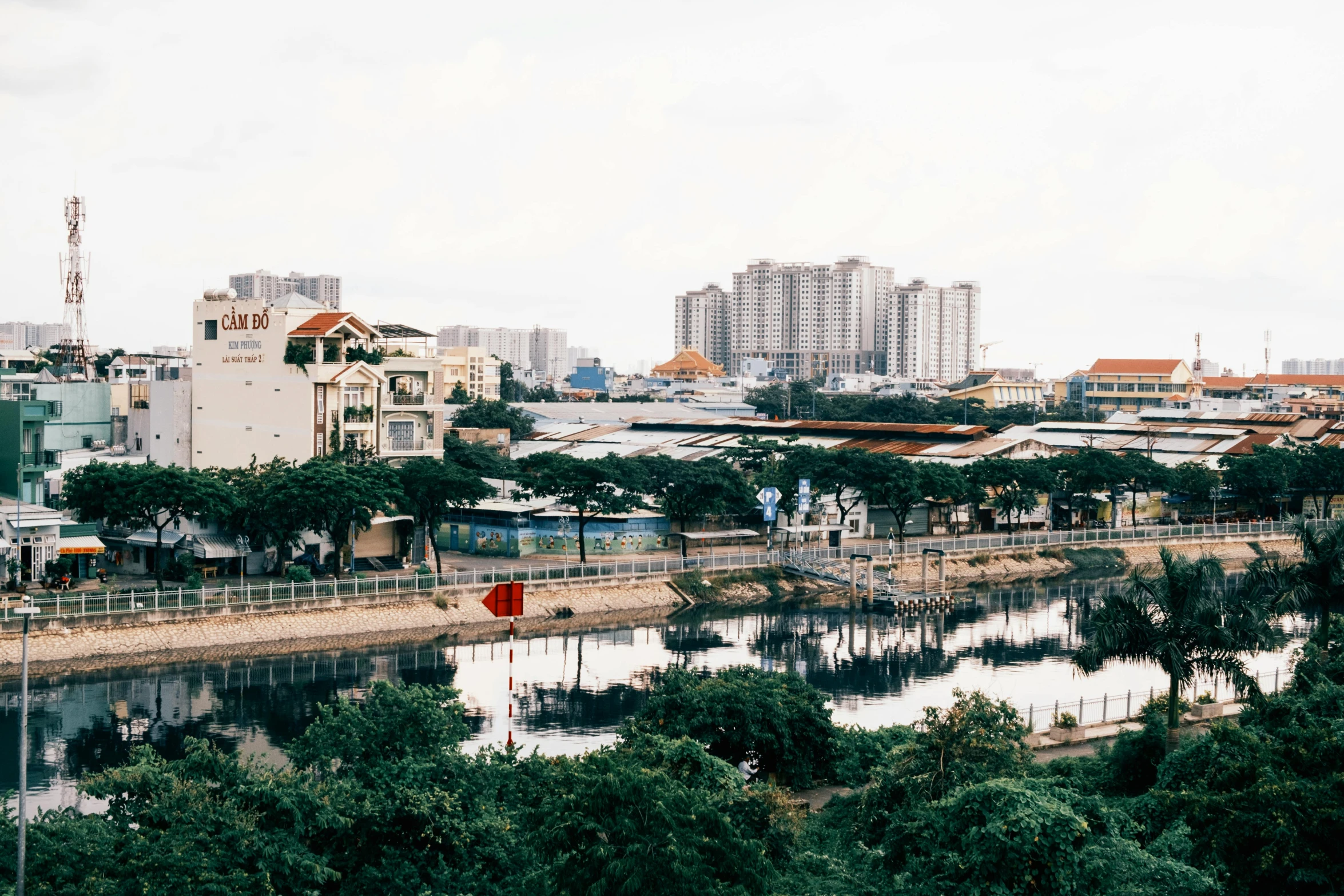 a city skyline showing buildings, a bridge, and trees