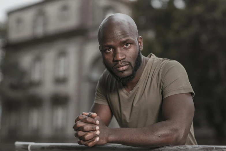 a man sitting with his hands crossed outside