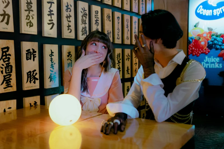 a man and woman sit at the table with chinese characters