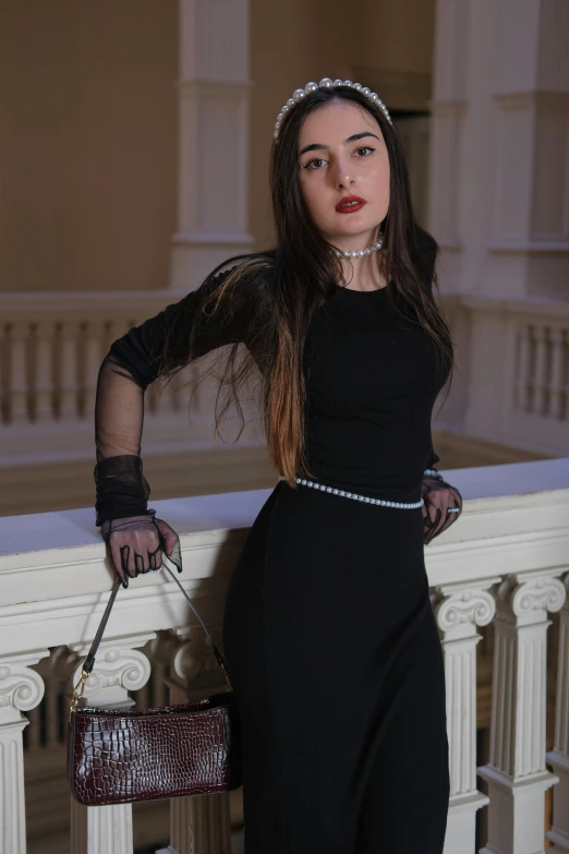 young female in a black dress is posing for a po