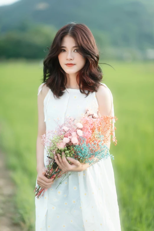 a woman in a white dress is holding flowers