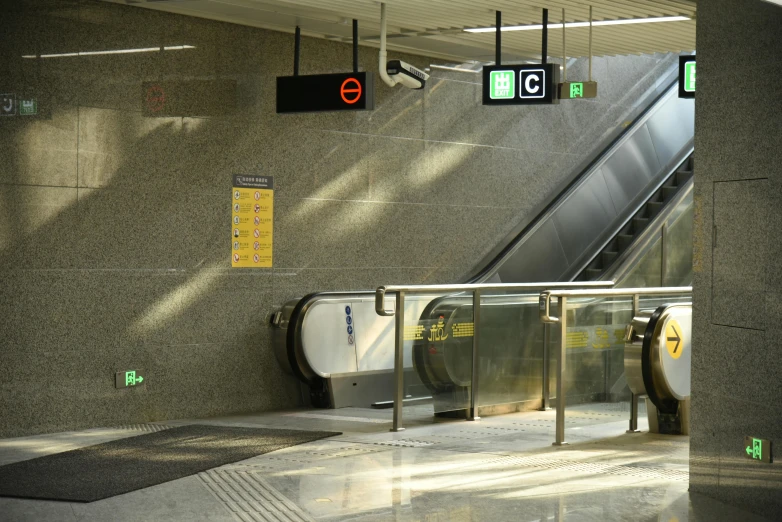 a walkway way with two escalators and a sign on the wall above them