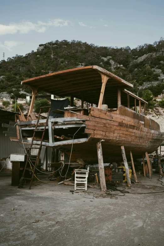 old wooden boat sitting on a trailer under construction