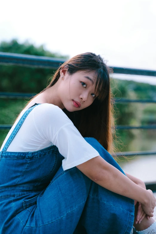 a young woman sits on a railing outside