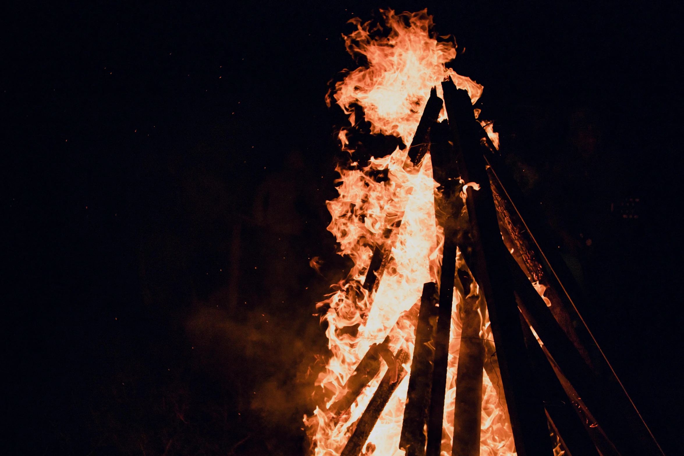 a burning piece of wood in the dark