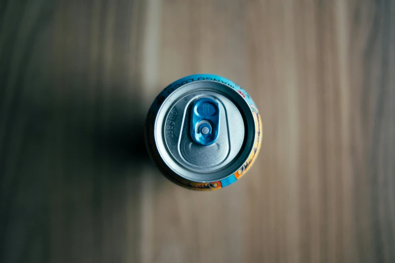 a can with the end of it on a wooden surface