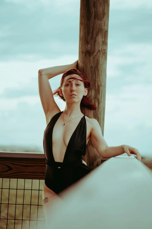 an attractive young lady in a black bathing suit posing for a po