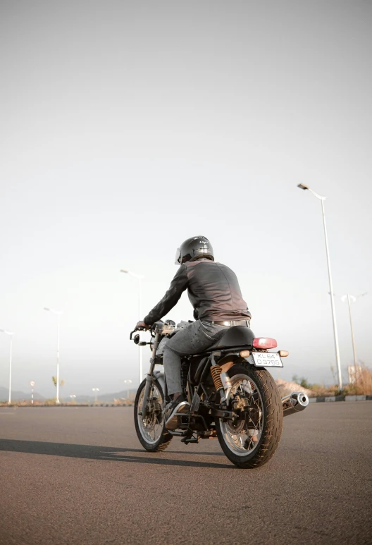 a man riding a motorcycle down the street on a nice day