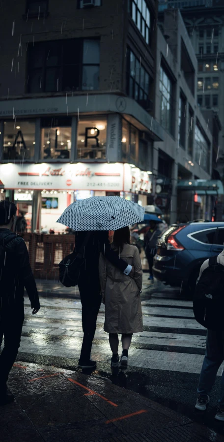 a couple sharing an umbrella on a rainy night