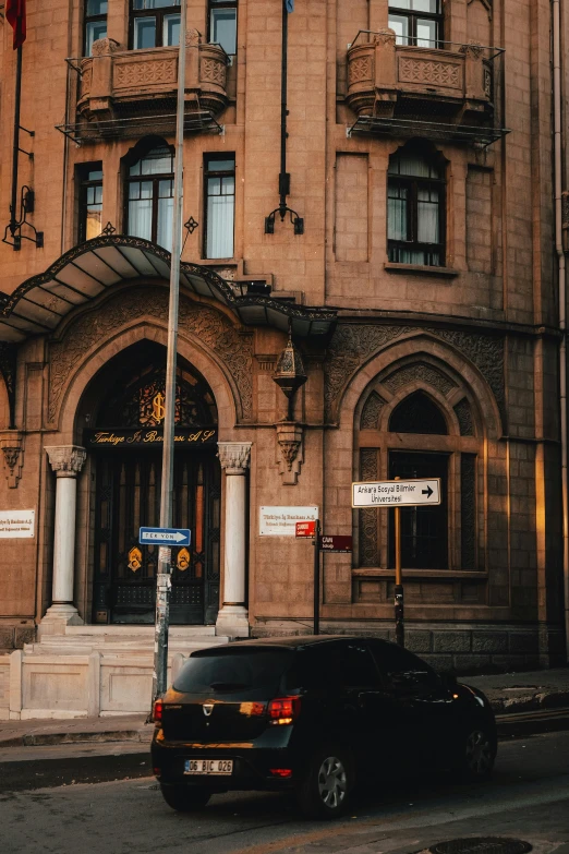 a dark colored car parked next to a brown building