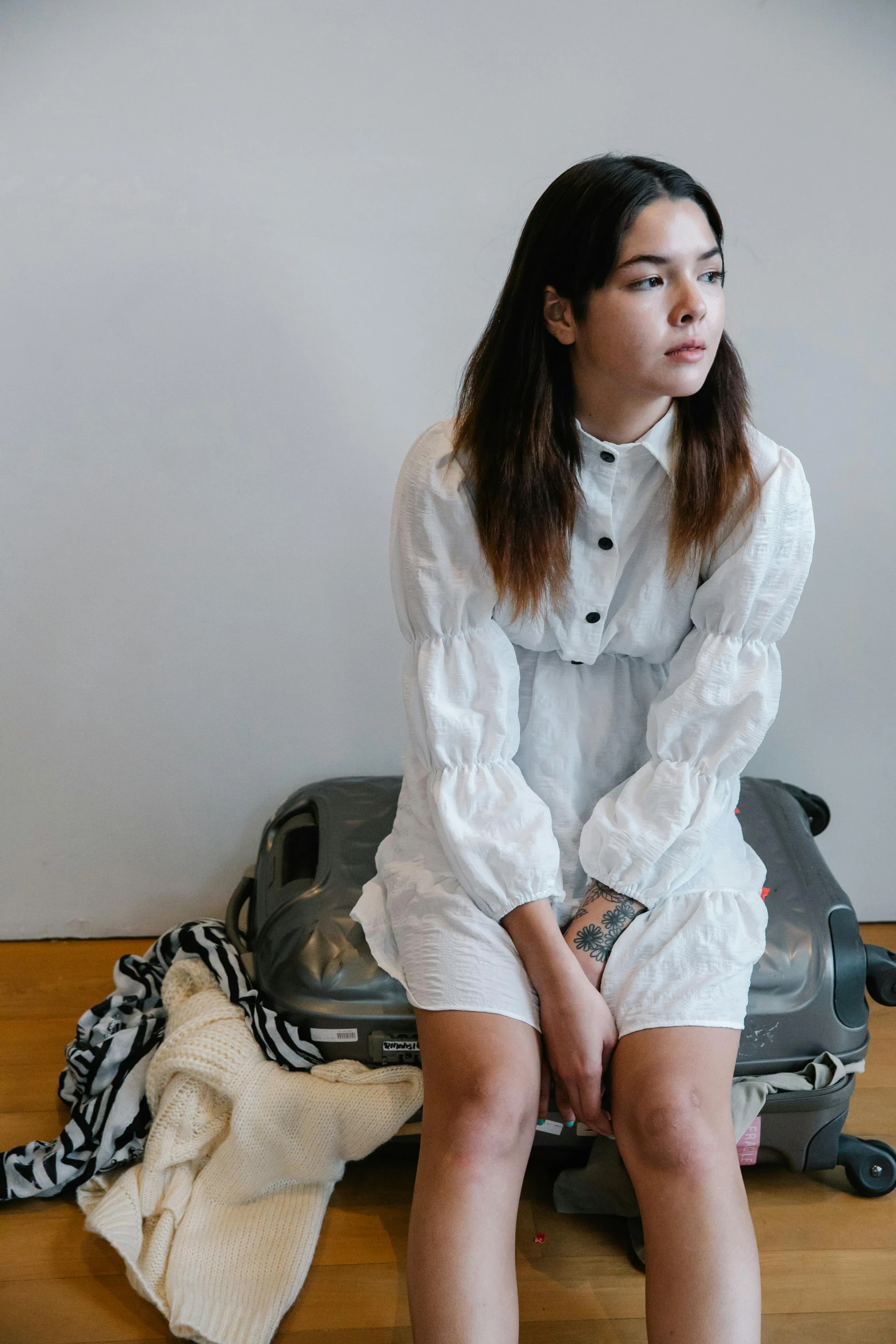 a young woman sitting on top of luggage