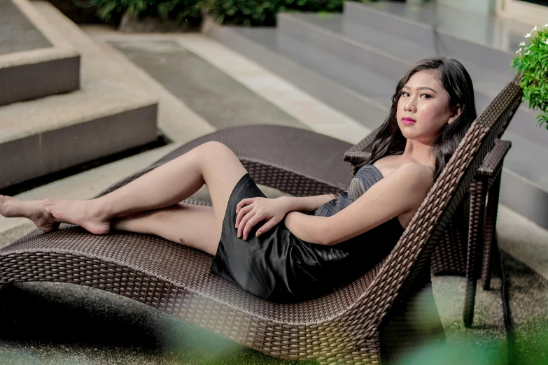 a woman sitting on top of a chair with her legs crossed