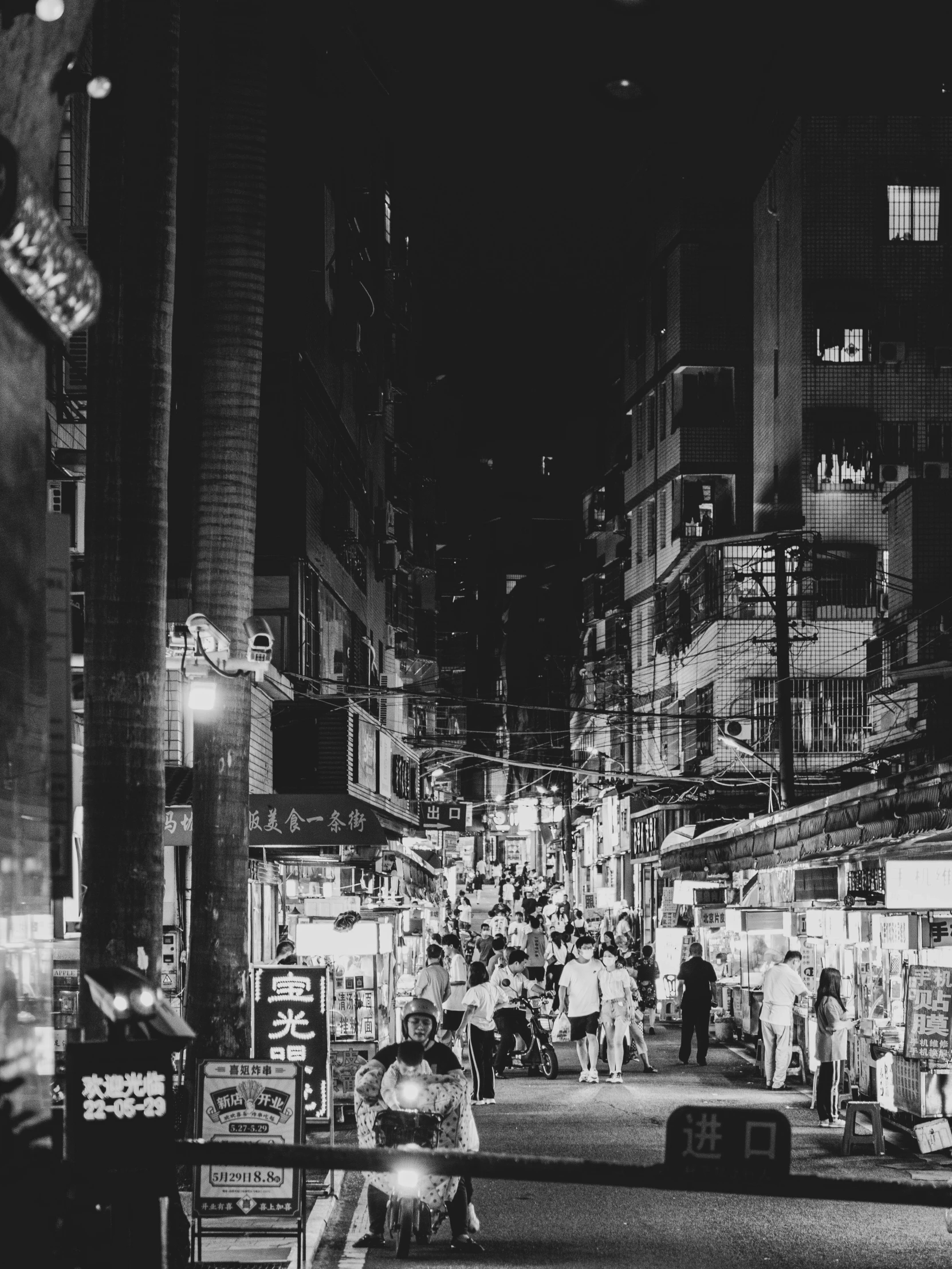 a crowded city street at night in black and white