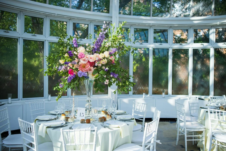 a large circular table with a tall vase on top of it