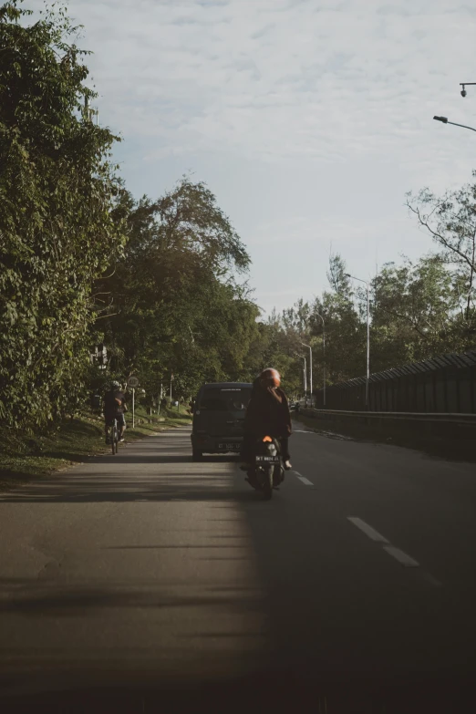 a person on a motorcycle drives along the road