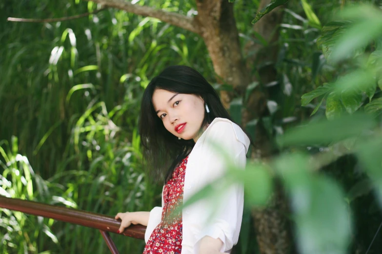 an image of a woman leaning on a rail in the woods