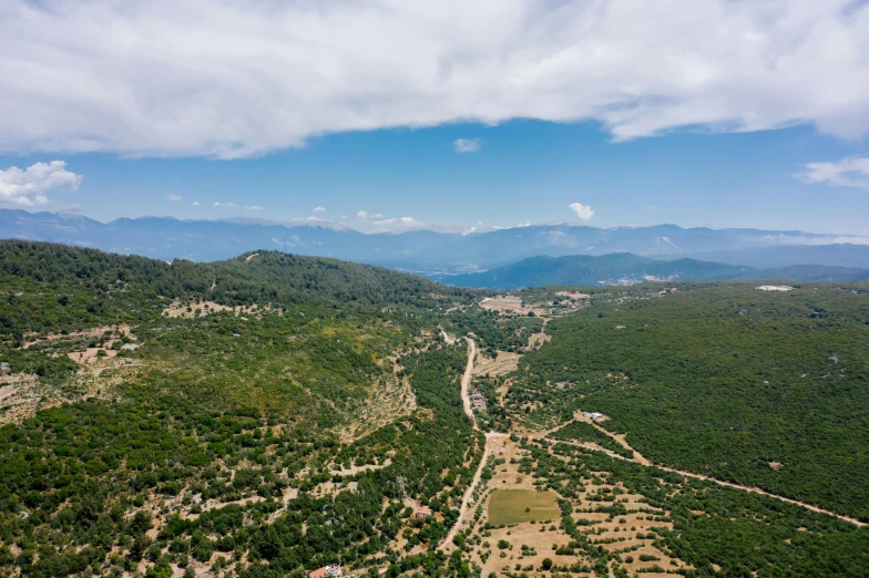 a wide river surrounded by mountains under a cloudy blue sky