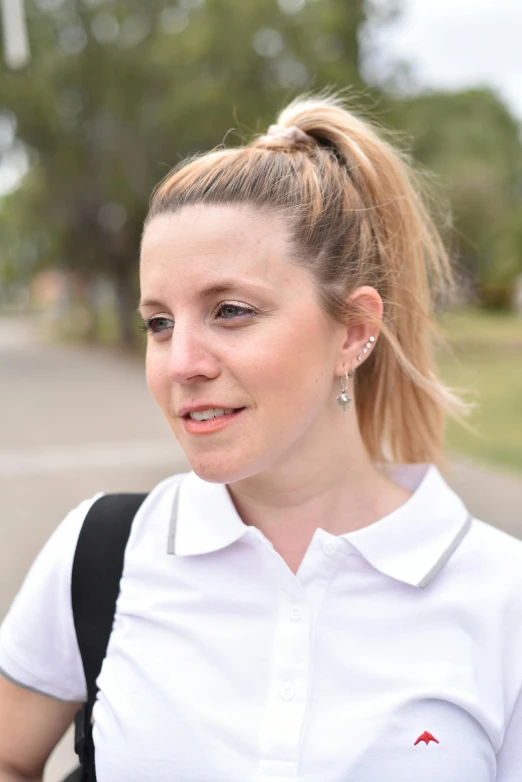 a woman with a ponytail wearing white shirt