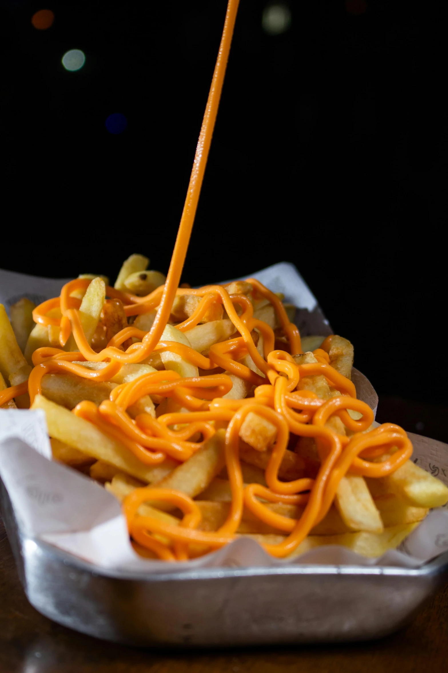 a tray with french fries, cheese and cheesy sauce