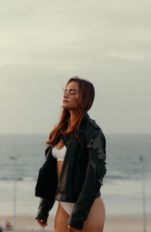 a young lady standing next to the ocean