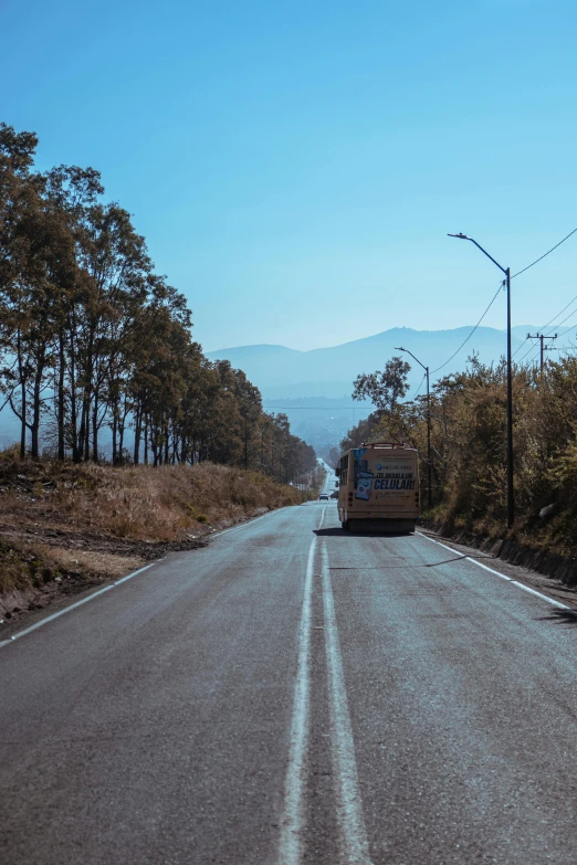 a bus traveling down a rural road in the mountains