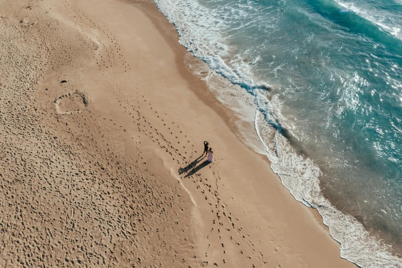 a beach with two surfers and waves