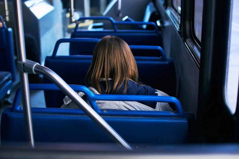 a girl sitting alone and looking out the window