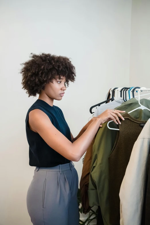 a woman looking at clothes on a rack