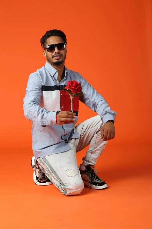 a person sitting down holding a flower in their hand