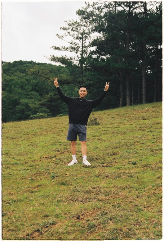 a man in shorts on the side of a hill waving