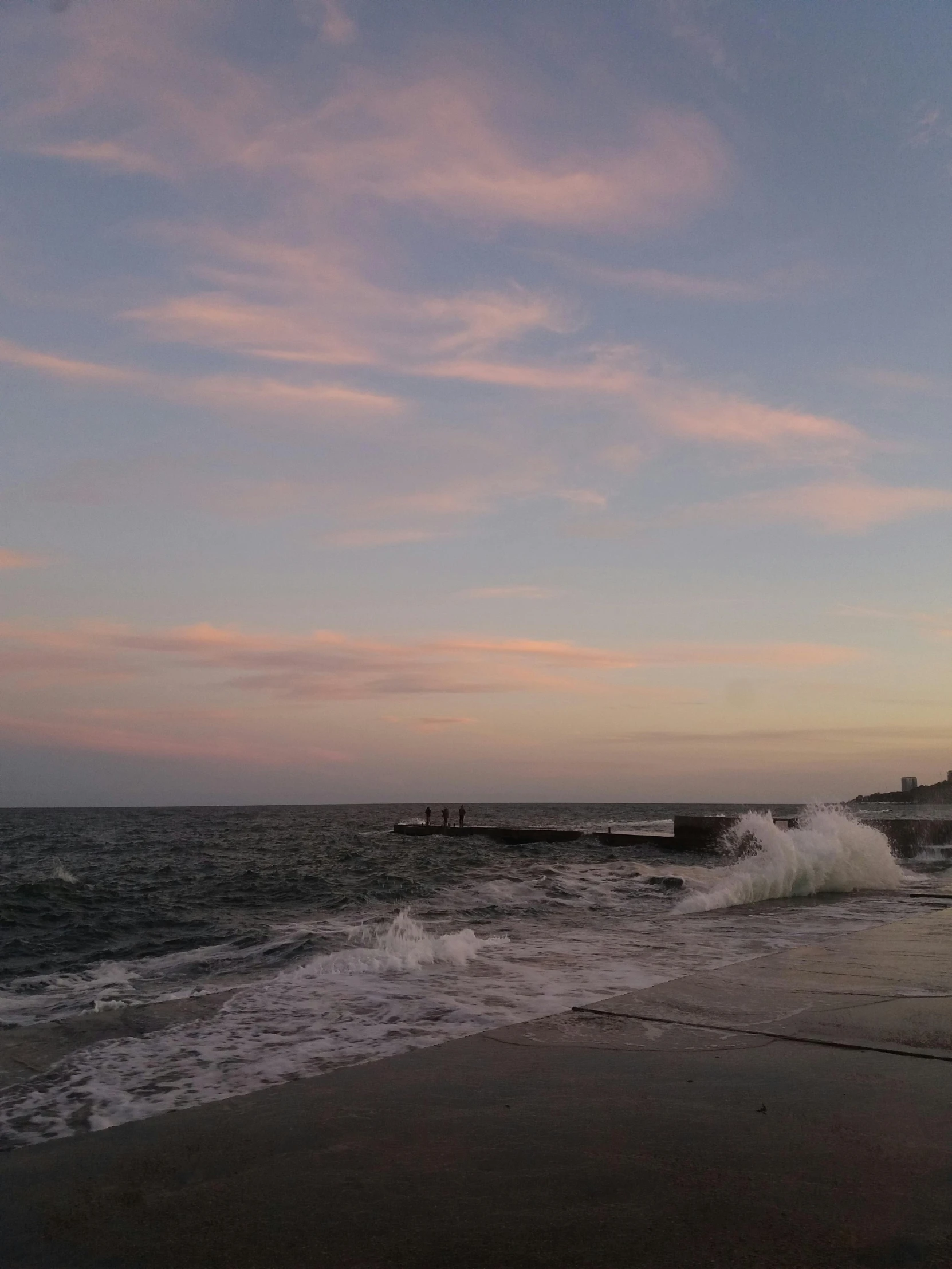 waves crashing on the shore line during sunset