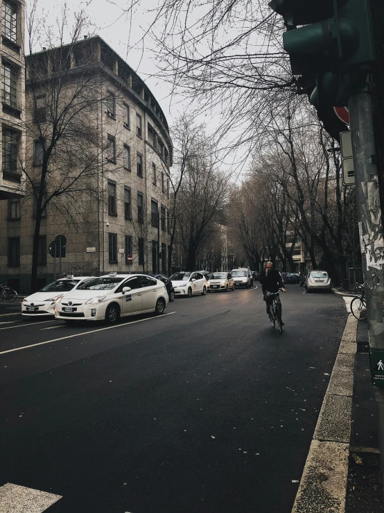 some cars and people riding on the sidewalk