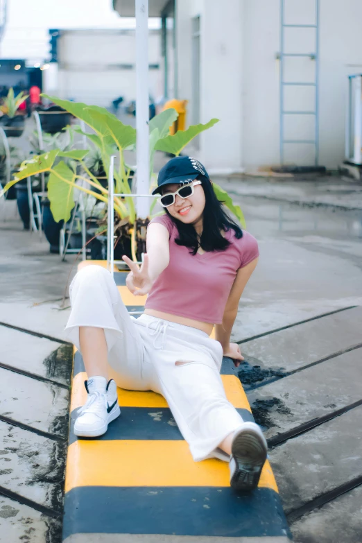 young lady sitting on yellow striped platform and making funny face