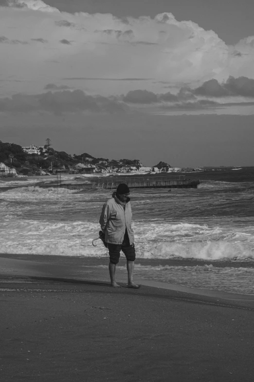 a person walking on the beach by the ocean