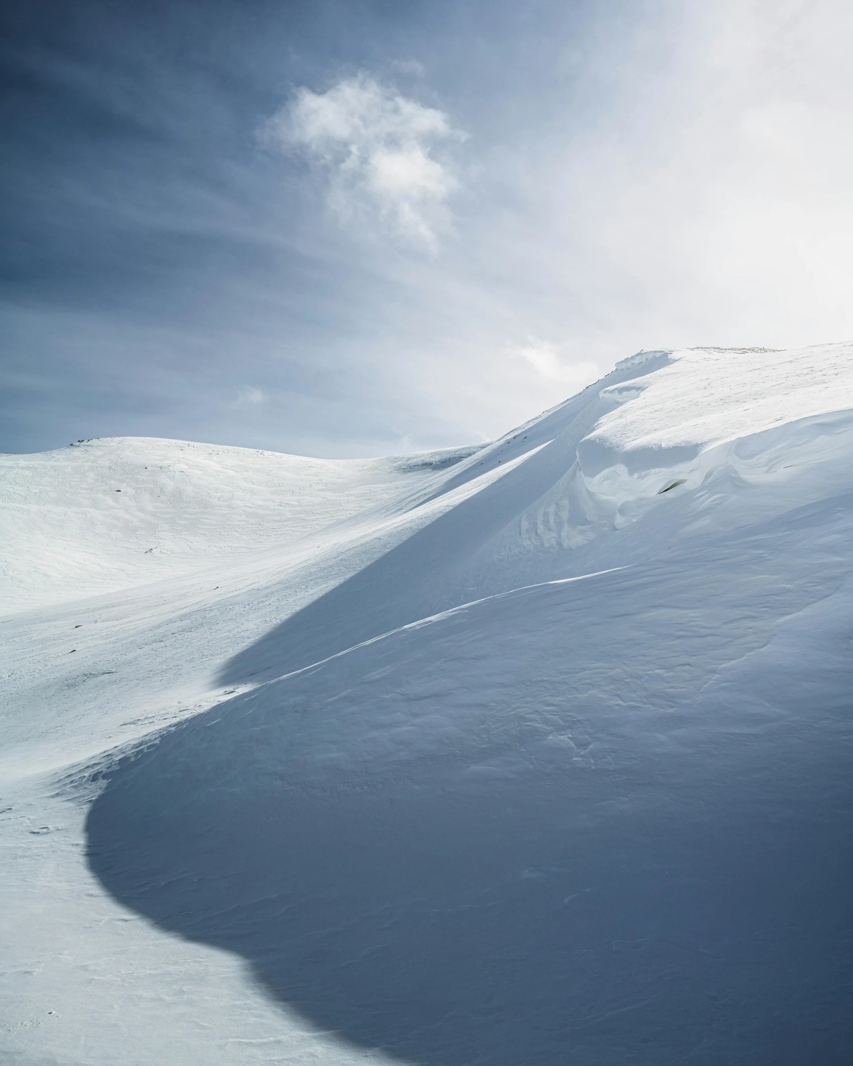 the snow covered side of a mountain is silhouetted by shadows