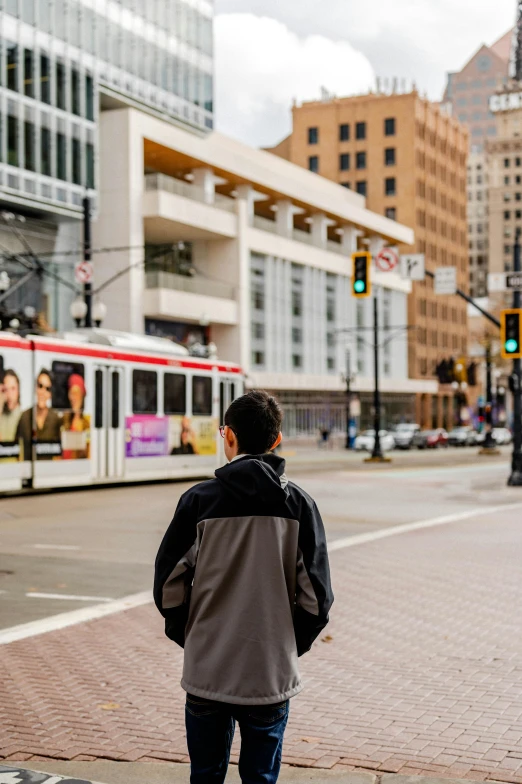 a man walking down a street past a bus