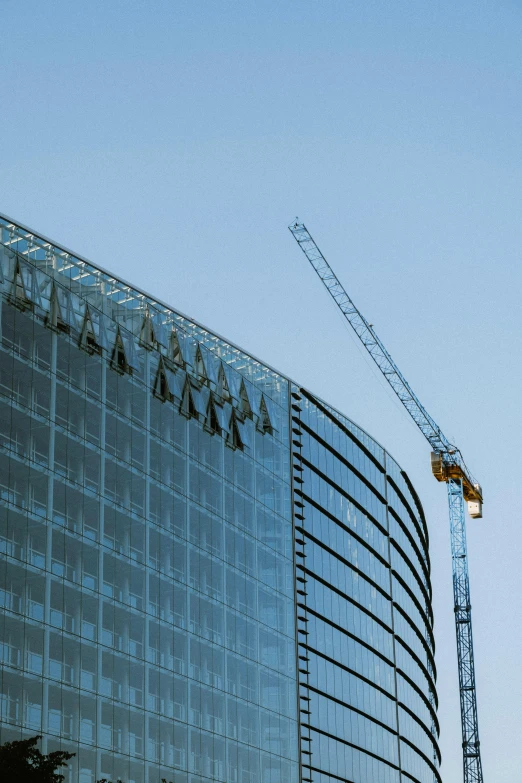 a crane and building with blue sky and clouds in the background