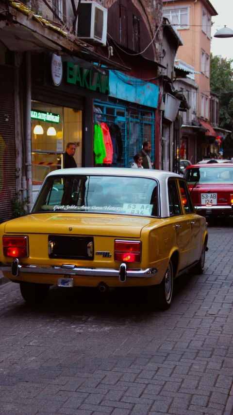 a man is sitting in the back of a yellow car on a busy street