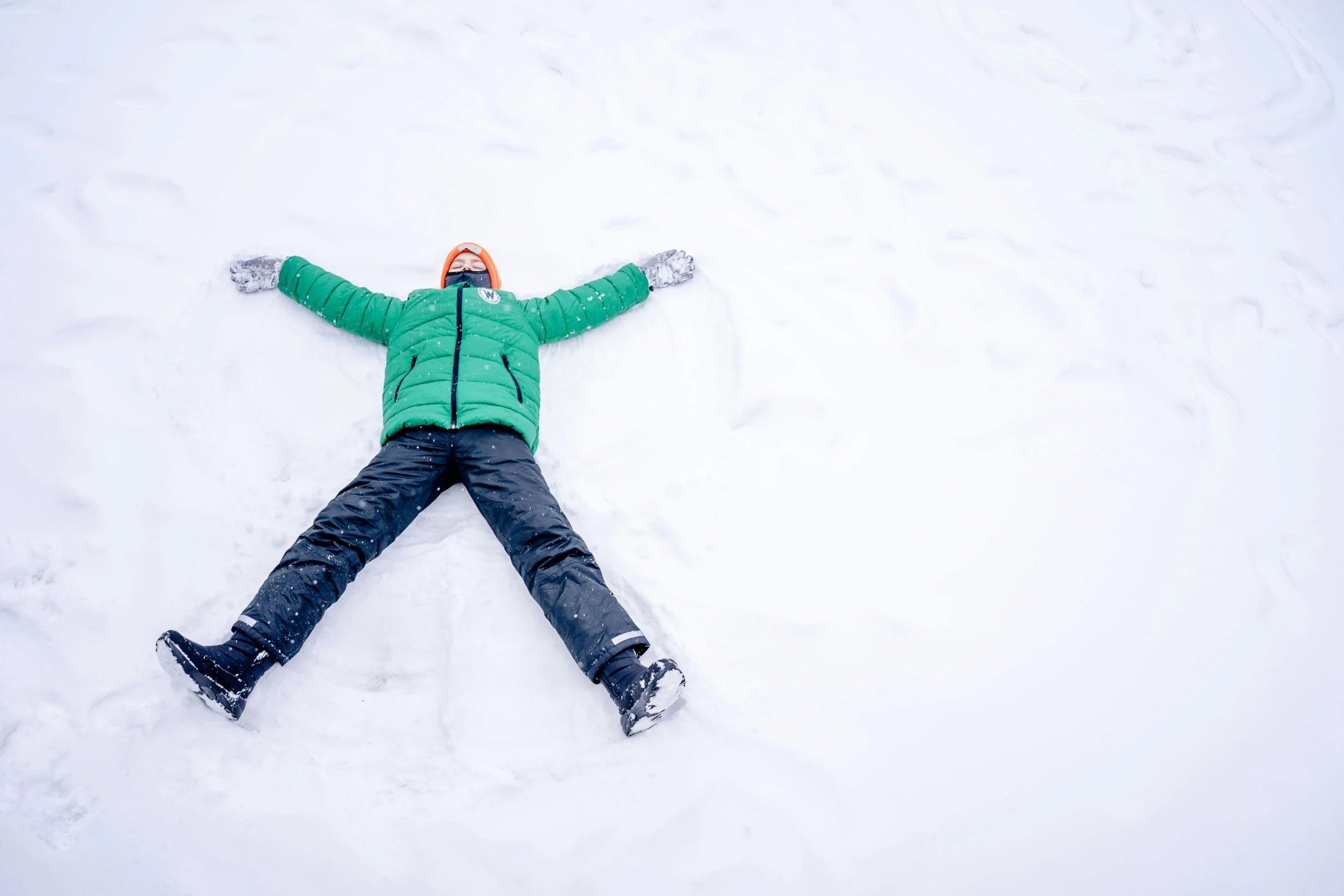 a man is laying on his back in the snow