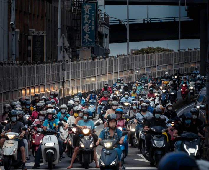 many people riding motorcycles down a street