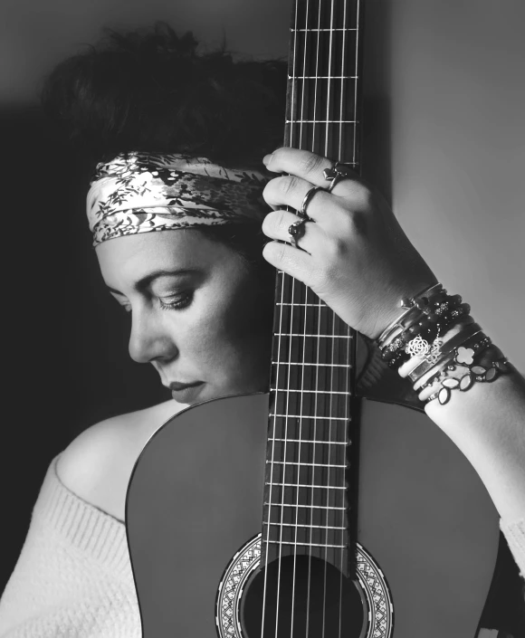 a woman holding a guitar up in her left hand