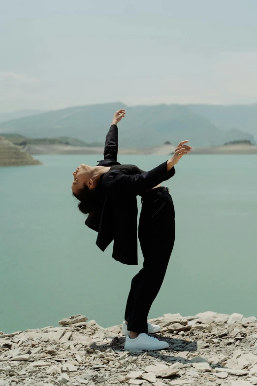 the woman is practicing her yoga poses by the water