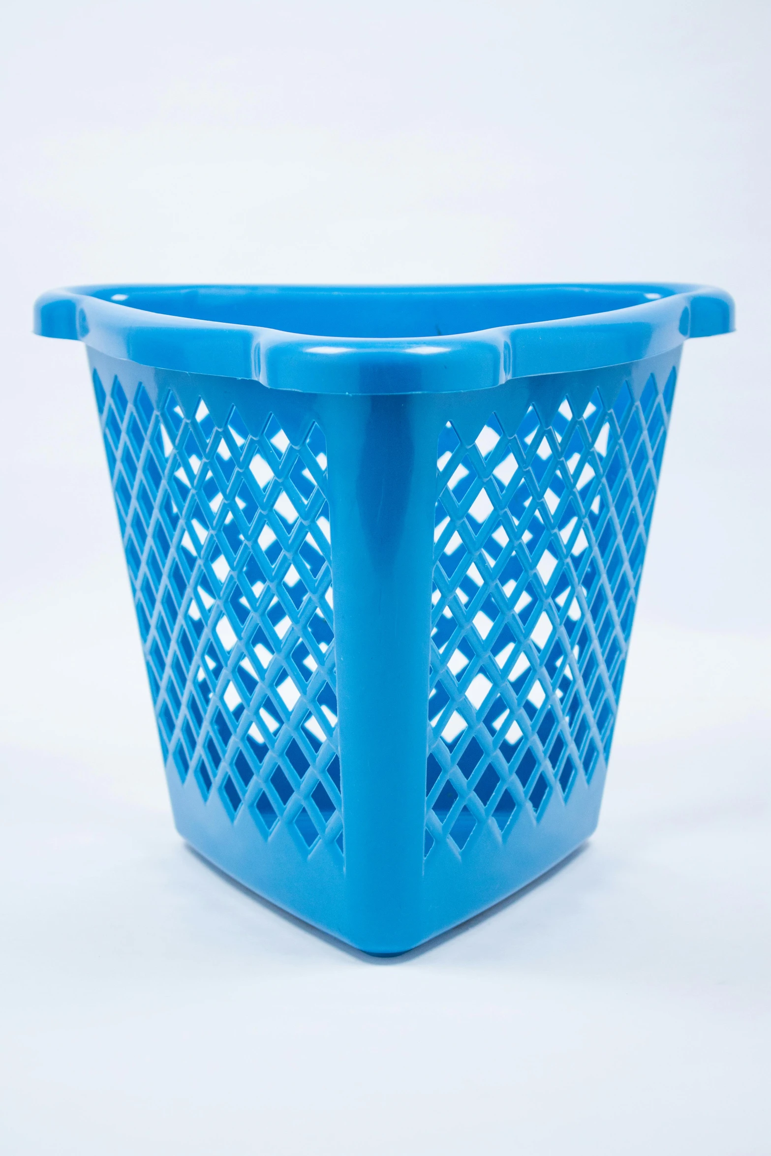 a blue basket with lattice design sits on the ground