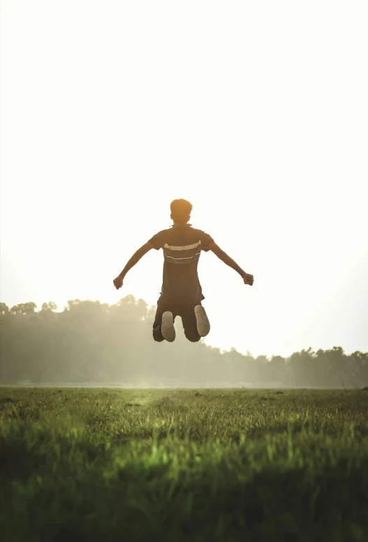 a person jumps in the air in a field