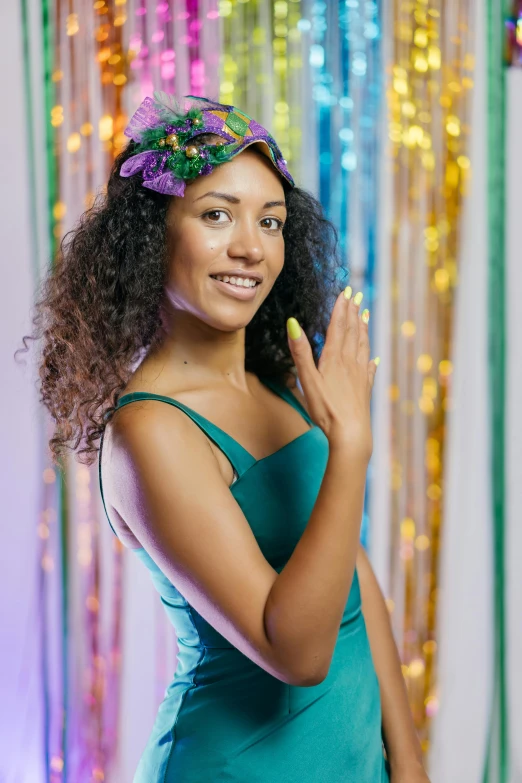 a girl in a blue dress standing in front of some colorful garland