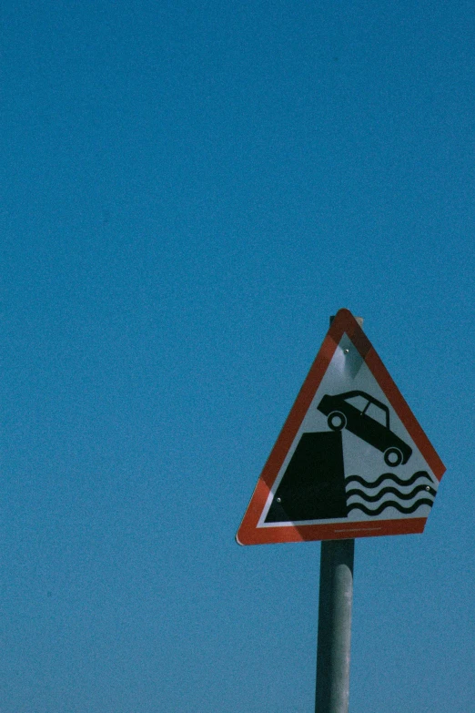 a close up of a traffic sign with an upside down car