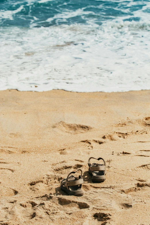 shoes and flip flops left on the beach